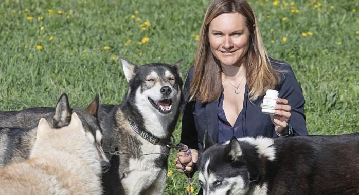 Valérie Maumon entourée de ses huskies, un pot ELEMENT VET à la main